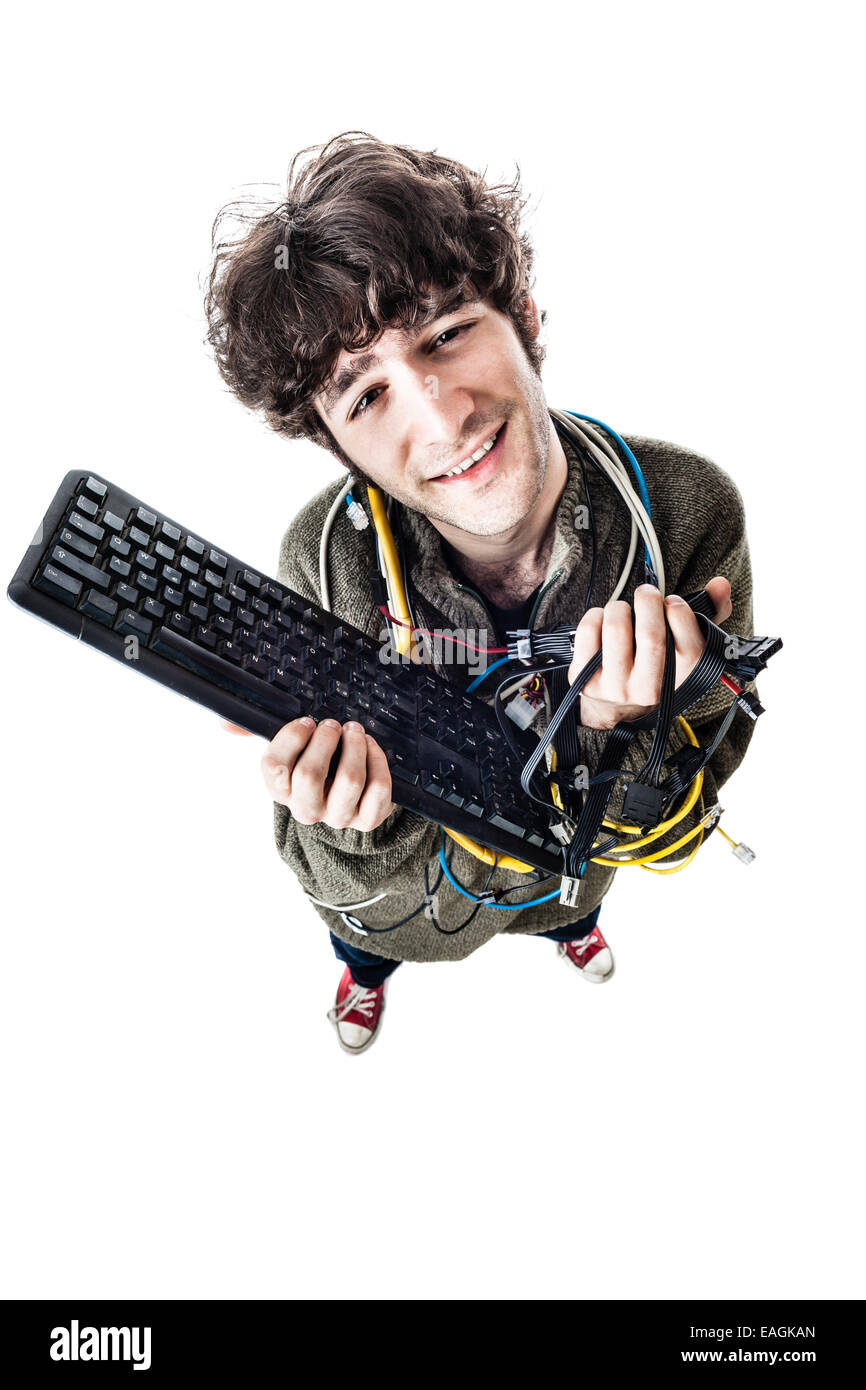 Un mec avec des câbles emmêlés et un clavier struggeling pour obtenir de l'aide de l'ordinateur. isolated on white Banque D'Images