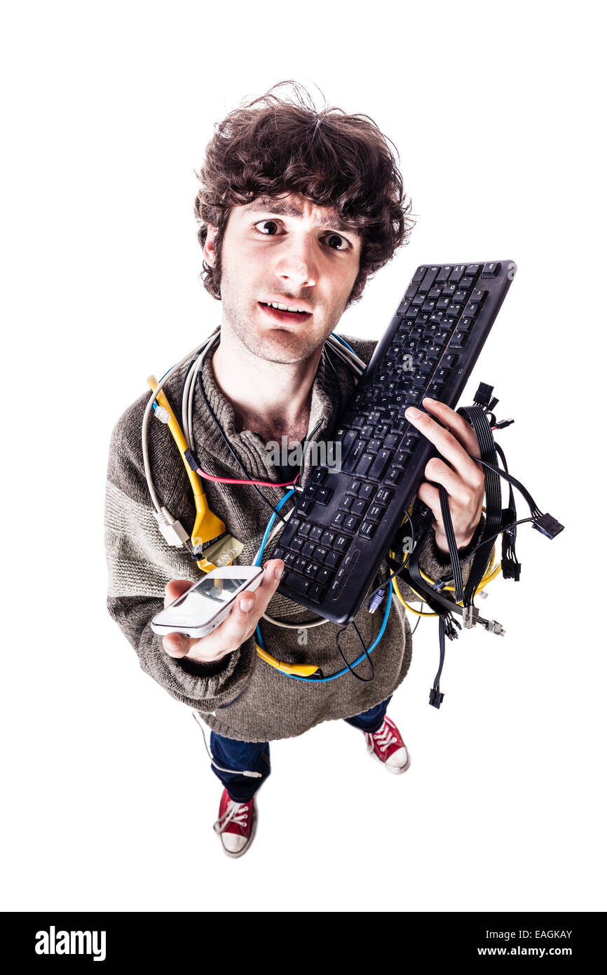 Un mec avec des câbles emmêlés et un clavier struggeling pour obtenir de l'aide de l'ordinateur. isolated on white Banque D'Images