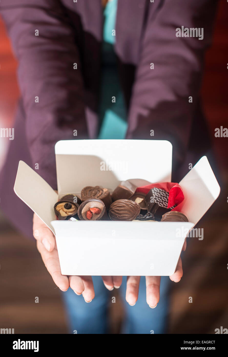 Mains tenant une boîte de chocolats. Close up Banque D'Images
