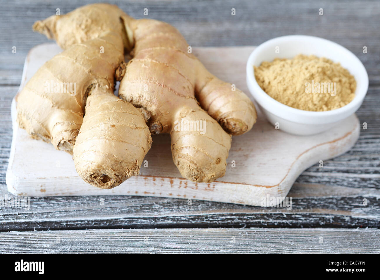 La racine de gingembre et le gingembre en poudre dans un bol on cutting board Banque D'Images