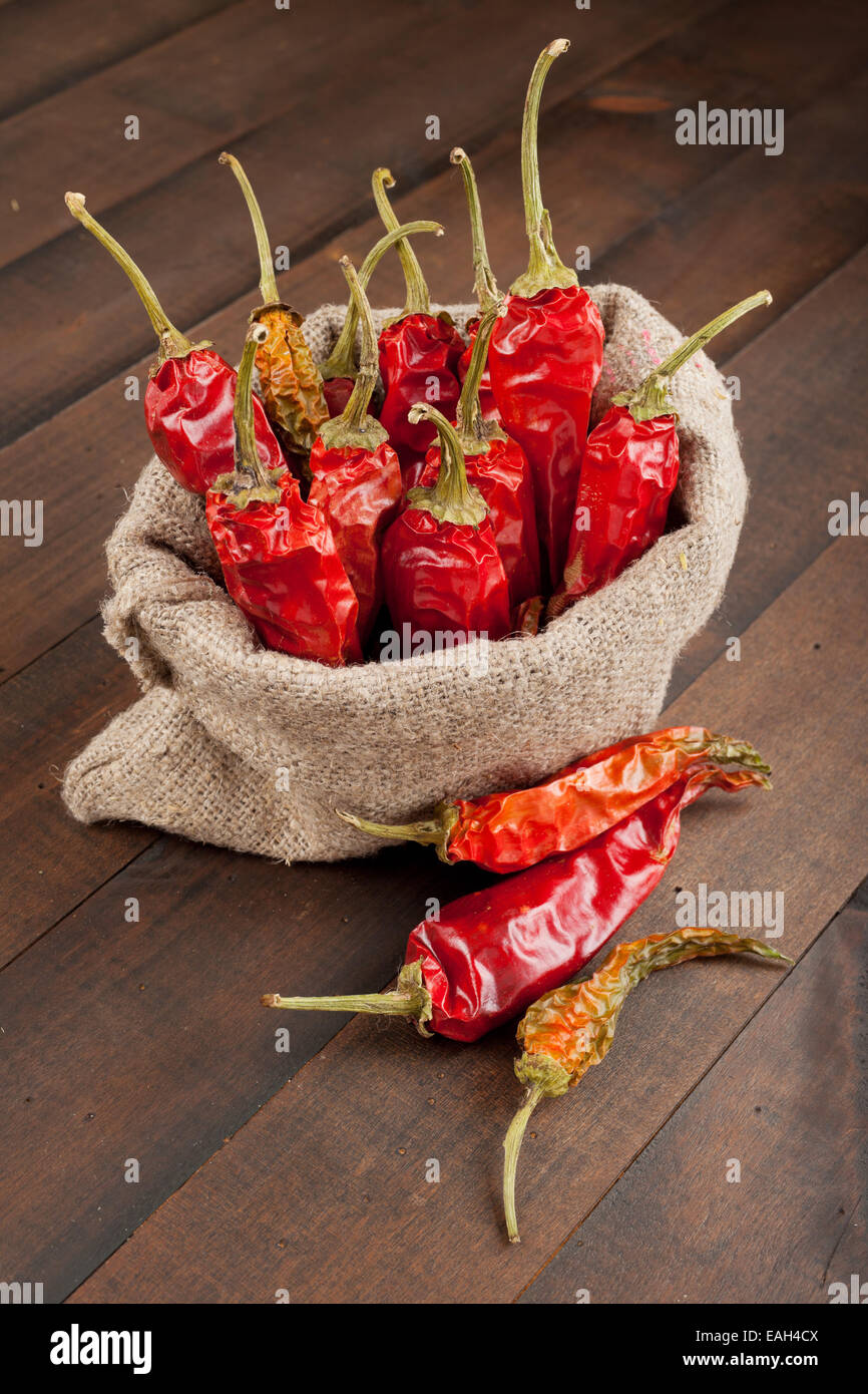 Piment rouge dans un sac en toile sur la table en bois Banque D'Images