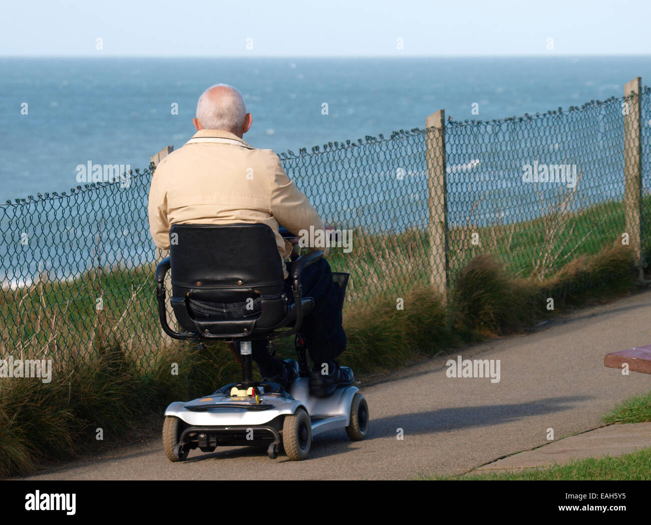 Vieil homme sur un scooter de mobilité le long de la côte, Bude, Cornwall, UK Banque D'Images