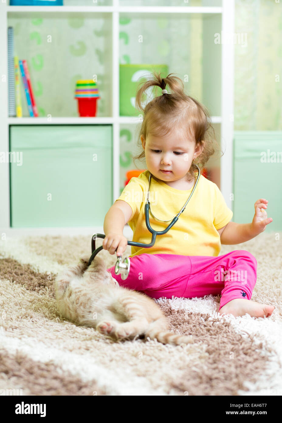 Petit enfant fille joue médecin avec chaton Banque D'Images