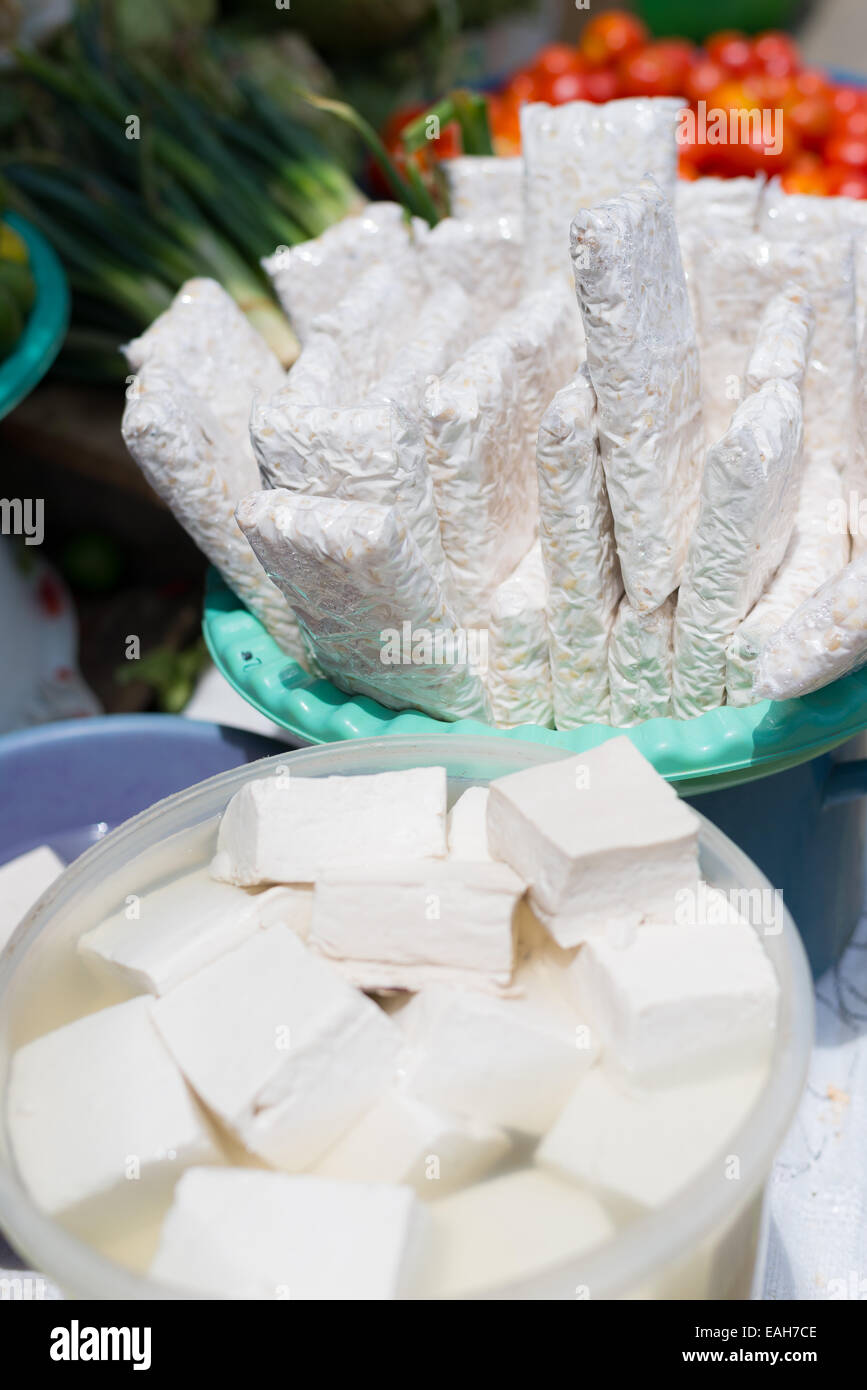 Produits de soja sur vendre en indonésien de la rue du marché. Selective focus sur les tranches de tempeh. Hors focale, cubes de tofu frais. Banque D'Images