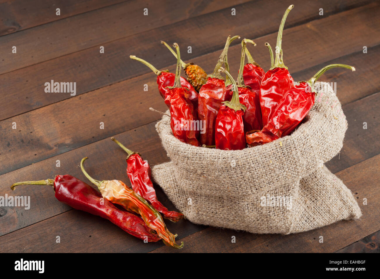 Piment rouge dans un sac en toile sur la table en bois Banque D'Images