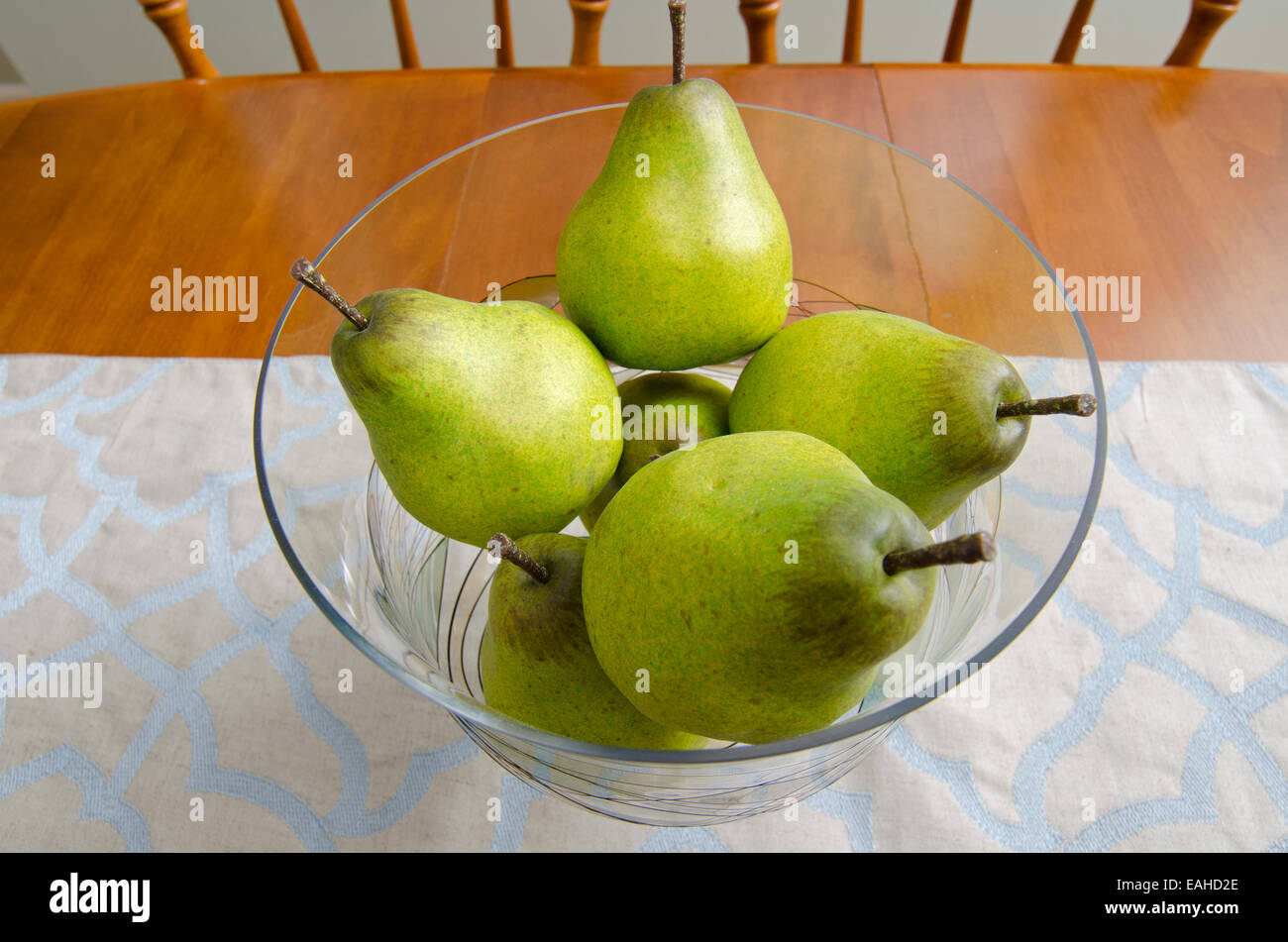 Poires : Les poires dans un bol en verre créer un centre de table décoratif pour une table à manger. Banque D'Images