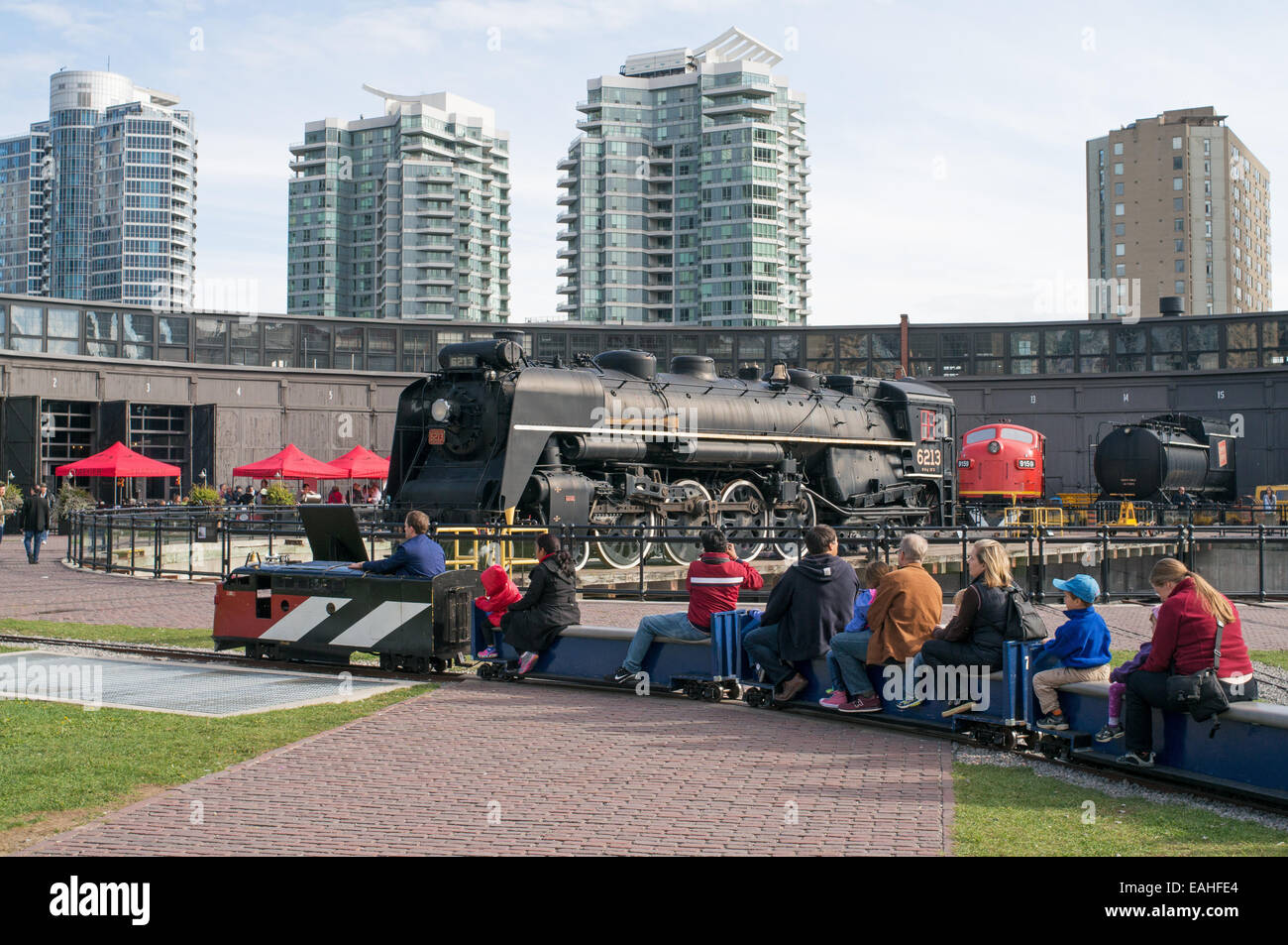 Petit train passant devant loco de vapeur 6213 à la Rotonde de John Street, Toronto Railway Heritage Centre, Ontario, Canada Banque D'Images