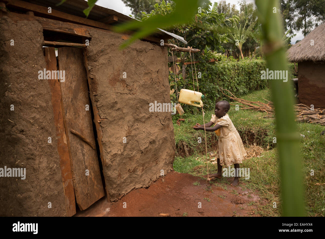 Une jeune fille se lave les mains à l'aide d'un robinet-tippy dans Bukwo, District de l'Ouganda, l'Afrique de l'Est. Banque D'Images