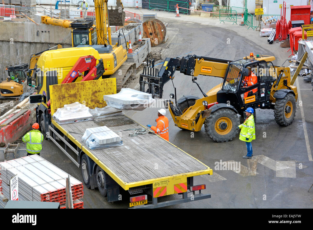 Vue aérienne bâtiment chantier de construction chariot élévateur à fourche déchargement camion camion livraison camion ouvriers port casque et veste haute visibilité Londres Royaume-Uni Banque D'Images