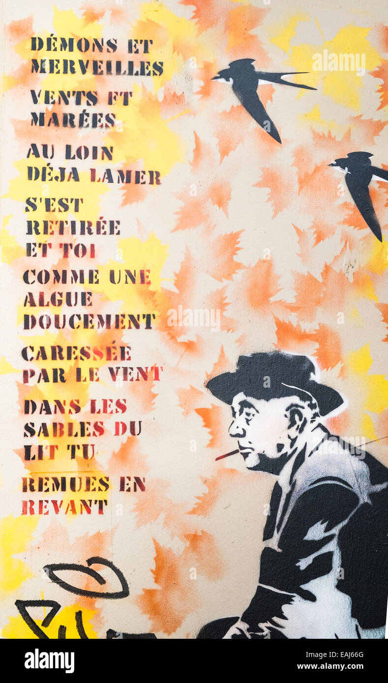 Graffito montrant poète français Jacques Prévert assis sur une chaise à côté des paroles de la chanson Démons et merveilles Banque D'Images