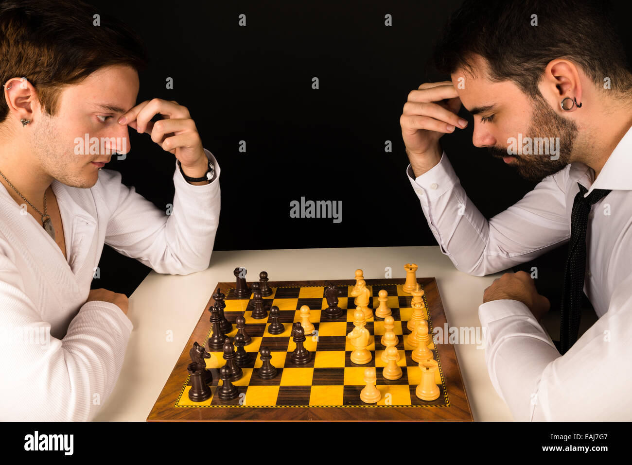 Deux gars dans la vingtaine concentrées en jouant aux échecs Banque D'Images
