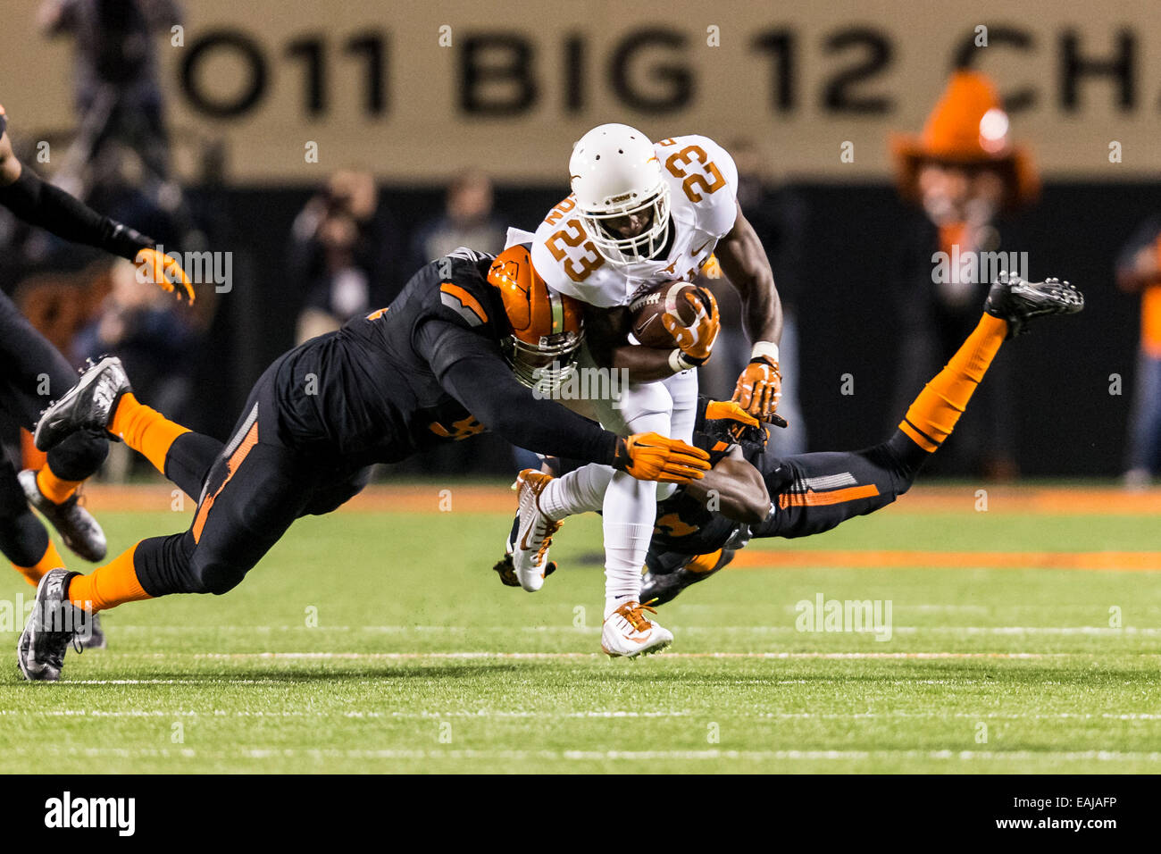 15 novembre 2104 : Texas longhorns wide receiver Daje Johnson (23) est abordé par l'Oklahoma State Cowboys coffre Tre fleurs (31) et l'Oklahoma State Cowboys attaquer défensif James Castleman (91) au cours de la NCAA football le jeu entre l'Oklahoma State Cowboys et le Texas longhorns à Boone Pickens Stadium à Stillwater, OK. Banque D'Images