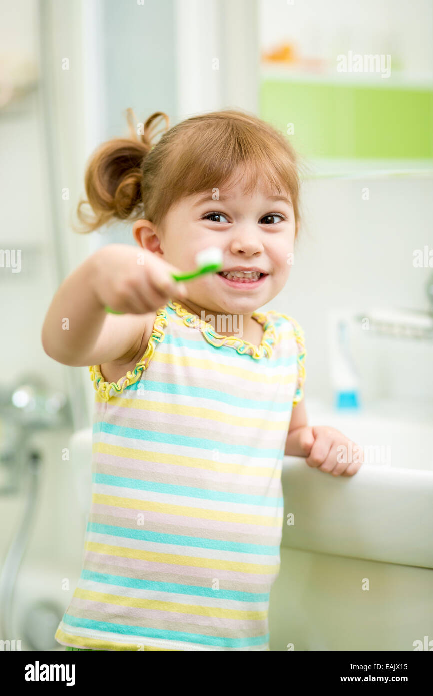 Fille enfant se brosser les dents dans la salle de bains Banque D'Images