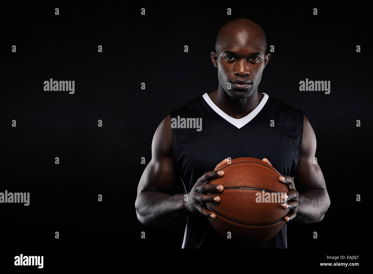 Portrait de l'Afrique de basket-ball professionnel joueur tenant une boule  en regardant la caméra. Mettre en place jeune homme avec le basket-ball  contre le noir Photo Stock - Alamy