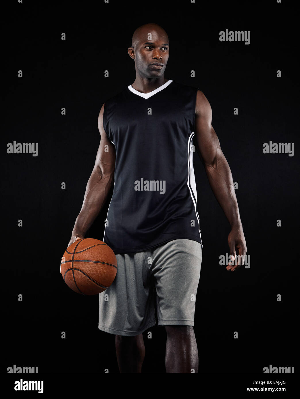 Portrait de joueur de basket-ball sur fond noir. Dans l'homme afro- sportswear holding a basket-ball à la route Photo Stock - Alamy