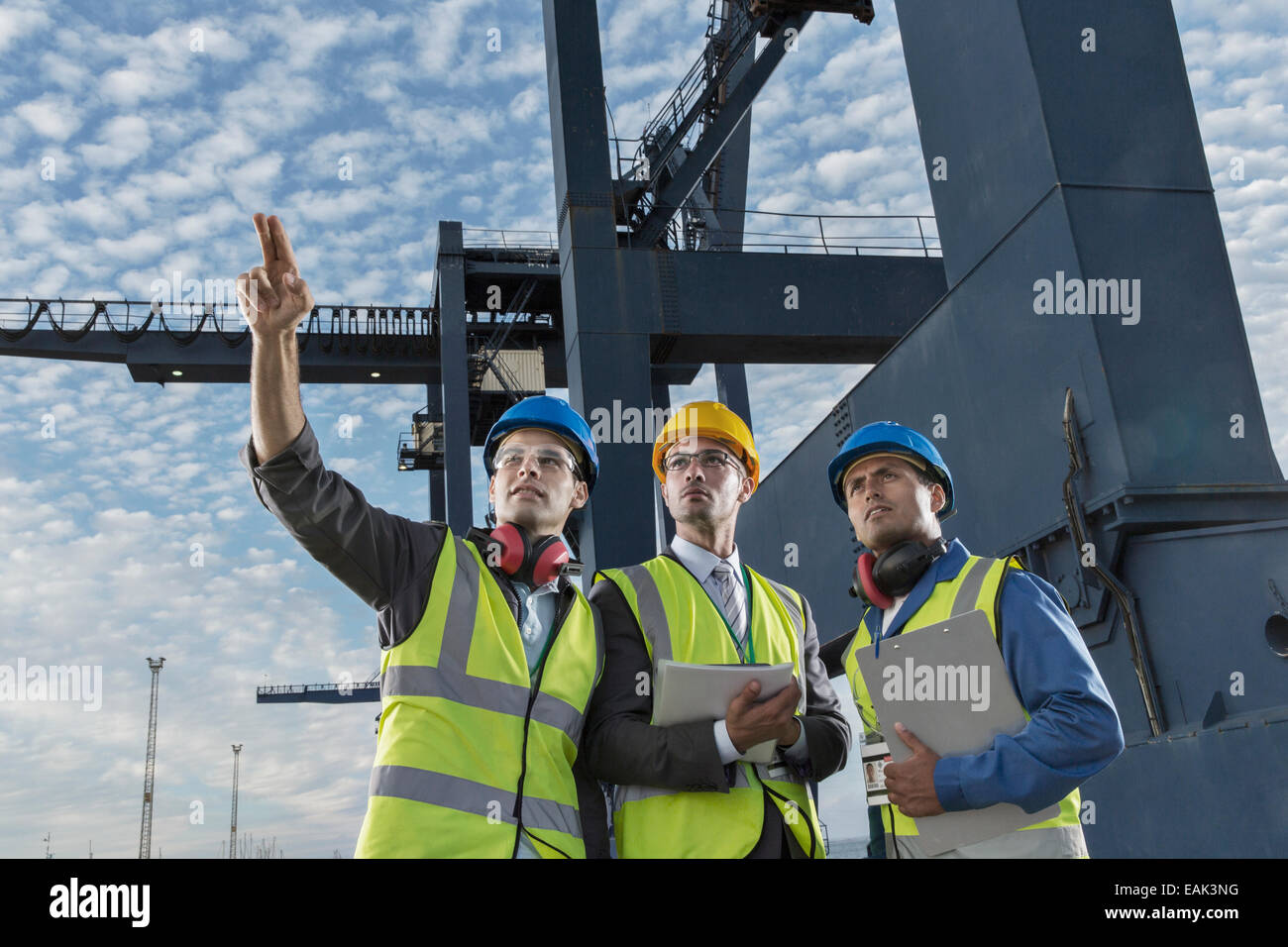 Les hommes d'affaires et worker talking près de cargo crane Banque D'Images
