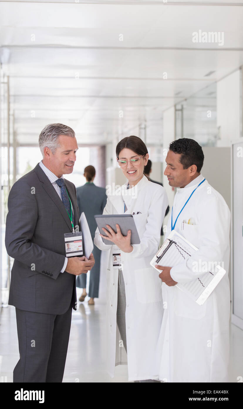 Les scientifiques et businessman using digital tablet in hallway Banque D'Images