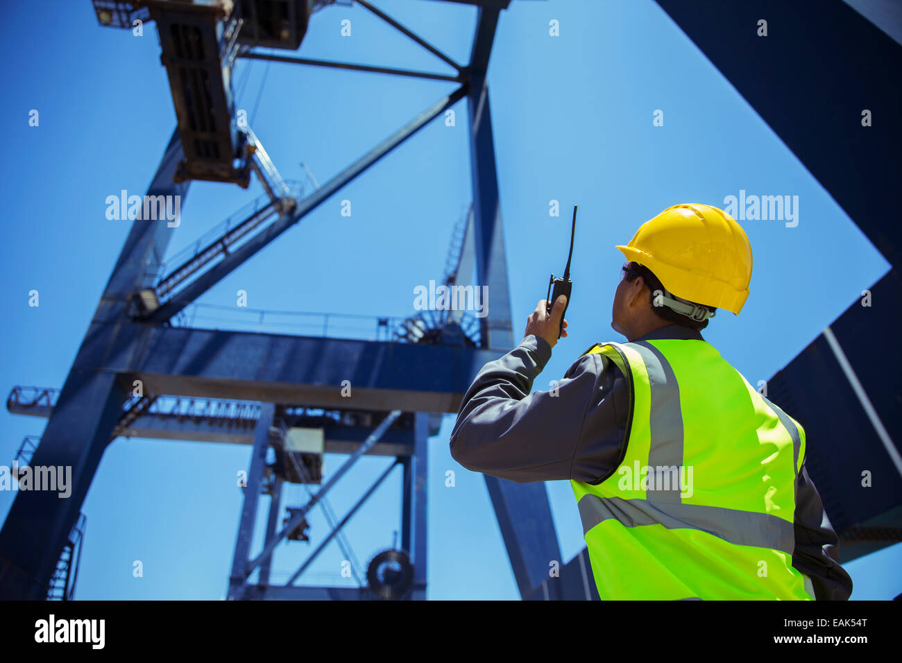 Low angle view of businessman using walkie-talkie sous grue de chargement Banque D'Images