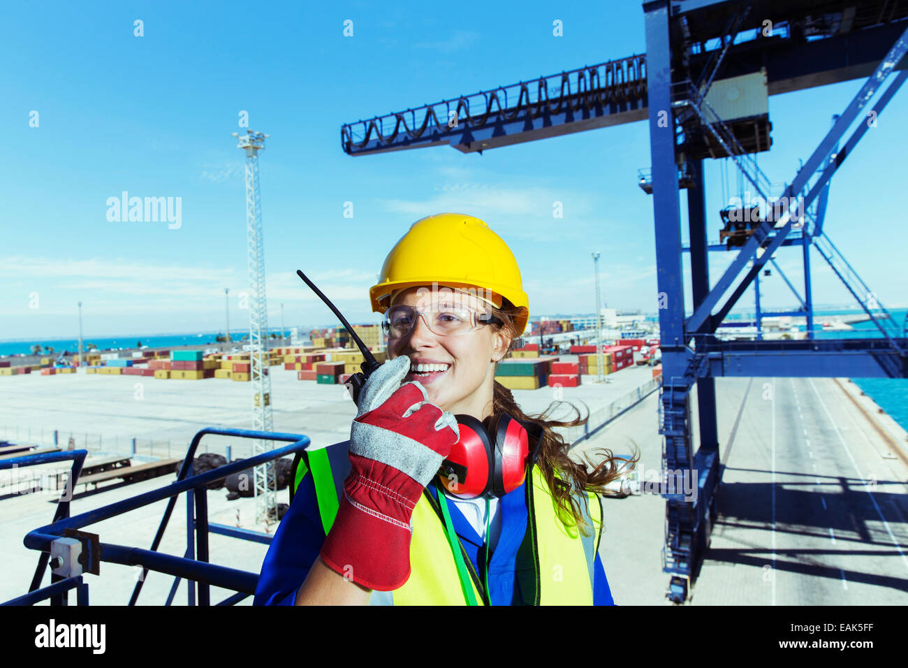 À l'aide de travailleurs talkie-walkie sur grue de chargement à bord de l'eau Banque D'Images