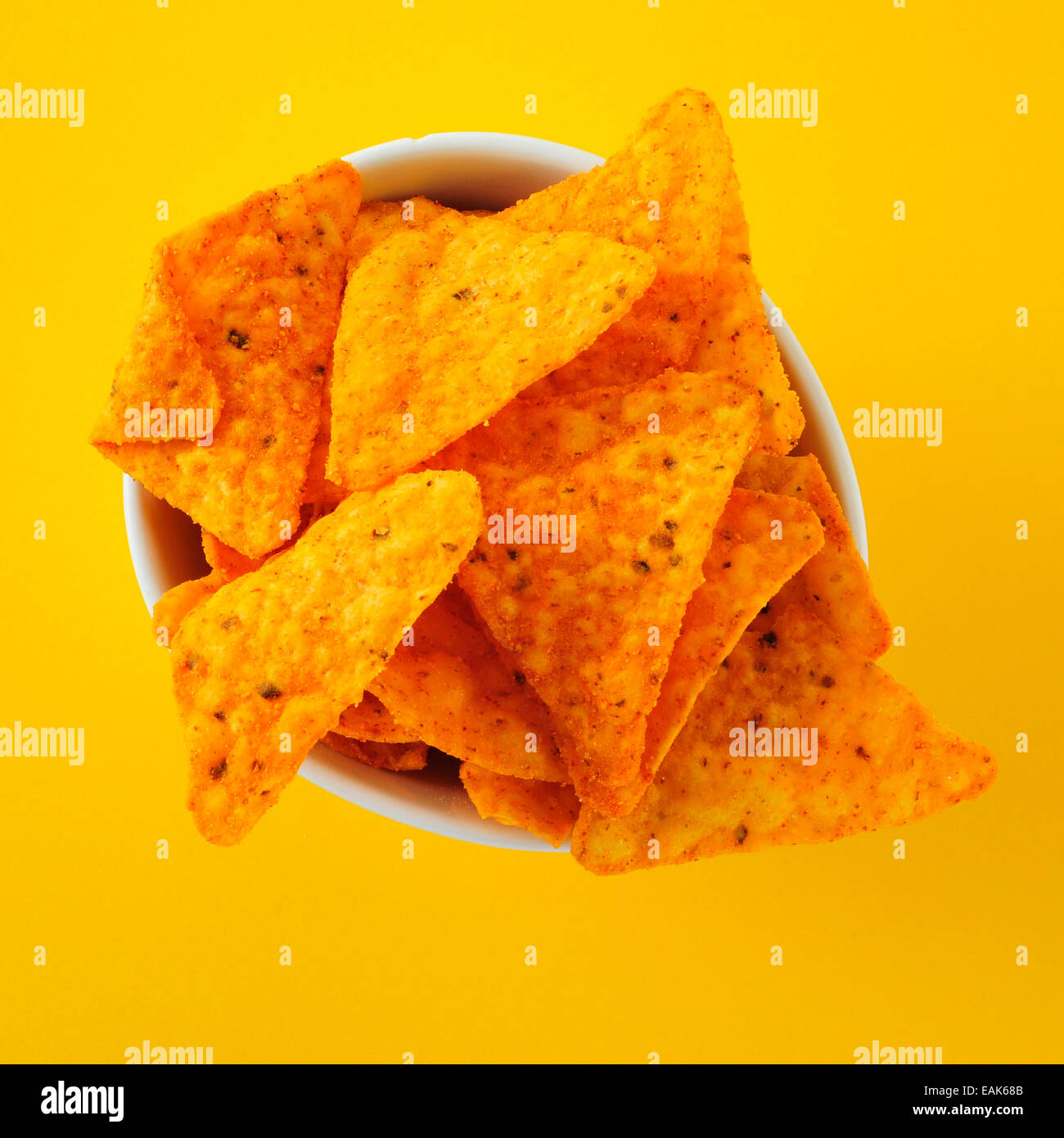 Un bol avec des croustilles sur fond jaune Banque D'Images