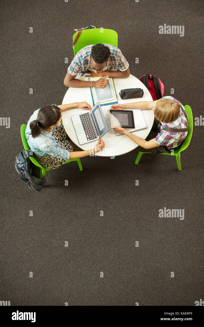 Vue aérienne d'élèves à faire leurs devoirs ensemble, à l'aide d'ordinateur portable et tablette numérique Banque D'Images