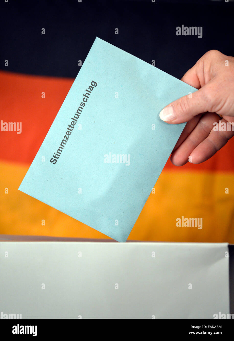 Image symbolique, les élections au Bundestag, part mettre une enveloppe dans une boîte de scrutin, devant le drapeau de l'Allemagne Banque D'Images