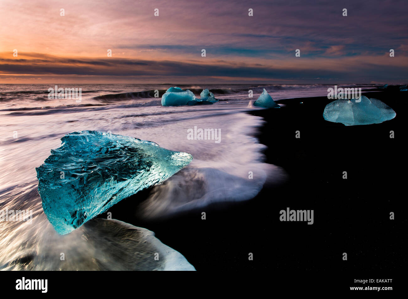 Des morceaux de glace sur la plage de lave noire au lever du soleil, Jökularsalon, Vik, Islande Banque D'Images