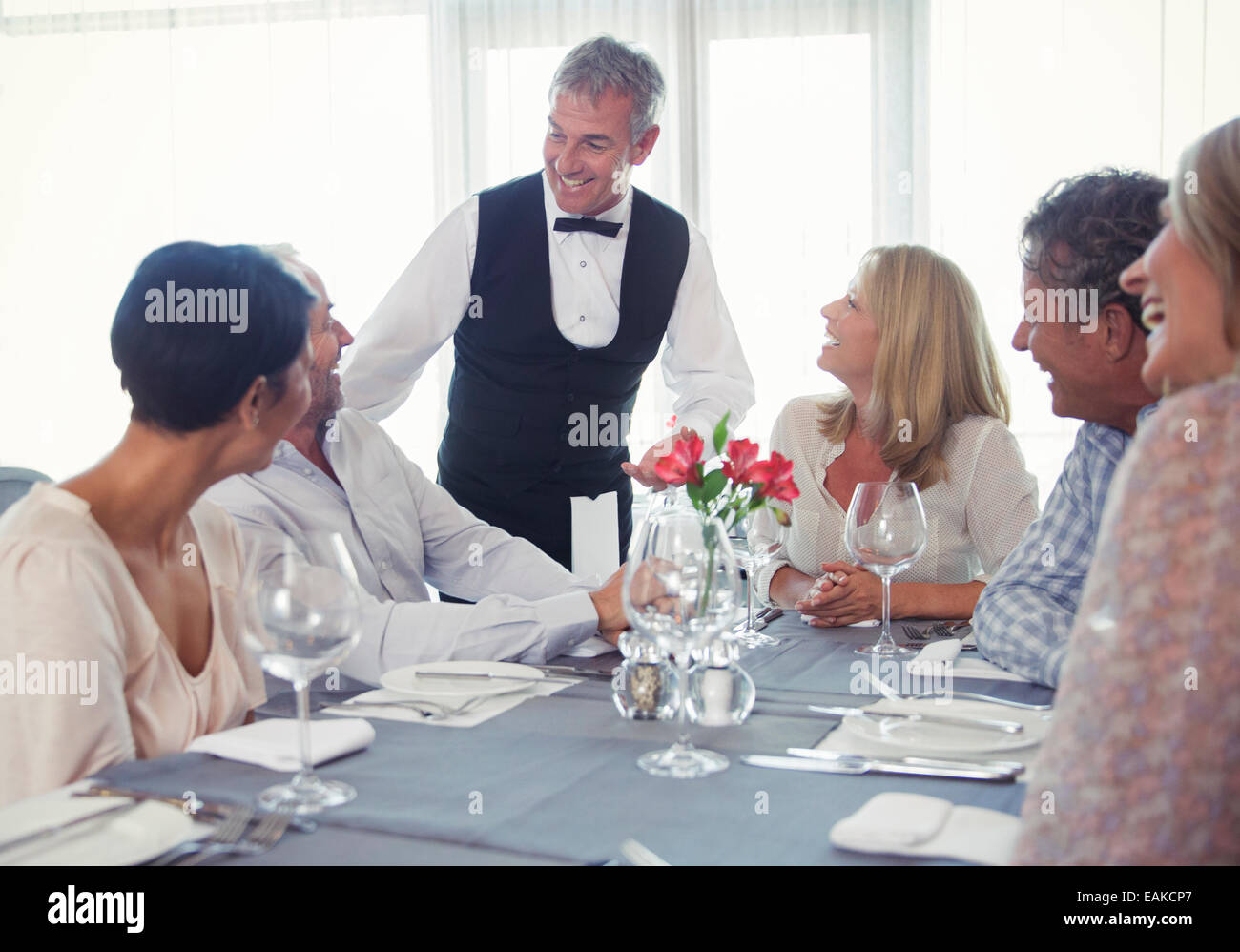 Les gens assis à table de restaurant et de parler à d'autres Banque D'Images