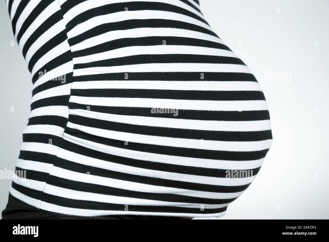 Close up of pregnant woman belly vêtu de noir haut rayé Banque D'Images