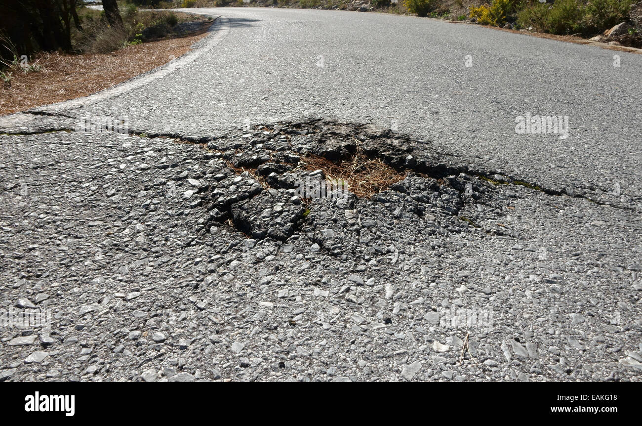 Vue faible de tarmac levées par les racines des arbres route dans les montagnes de Mijas, Andalousie, espagne. Banque D'Images