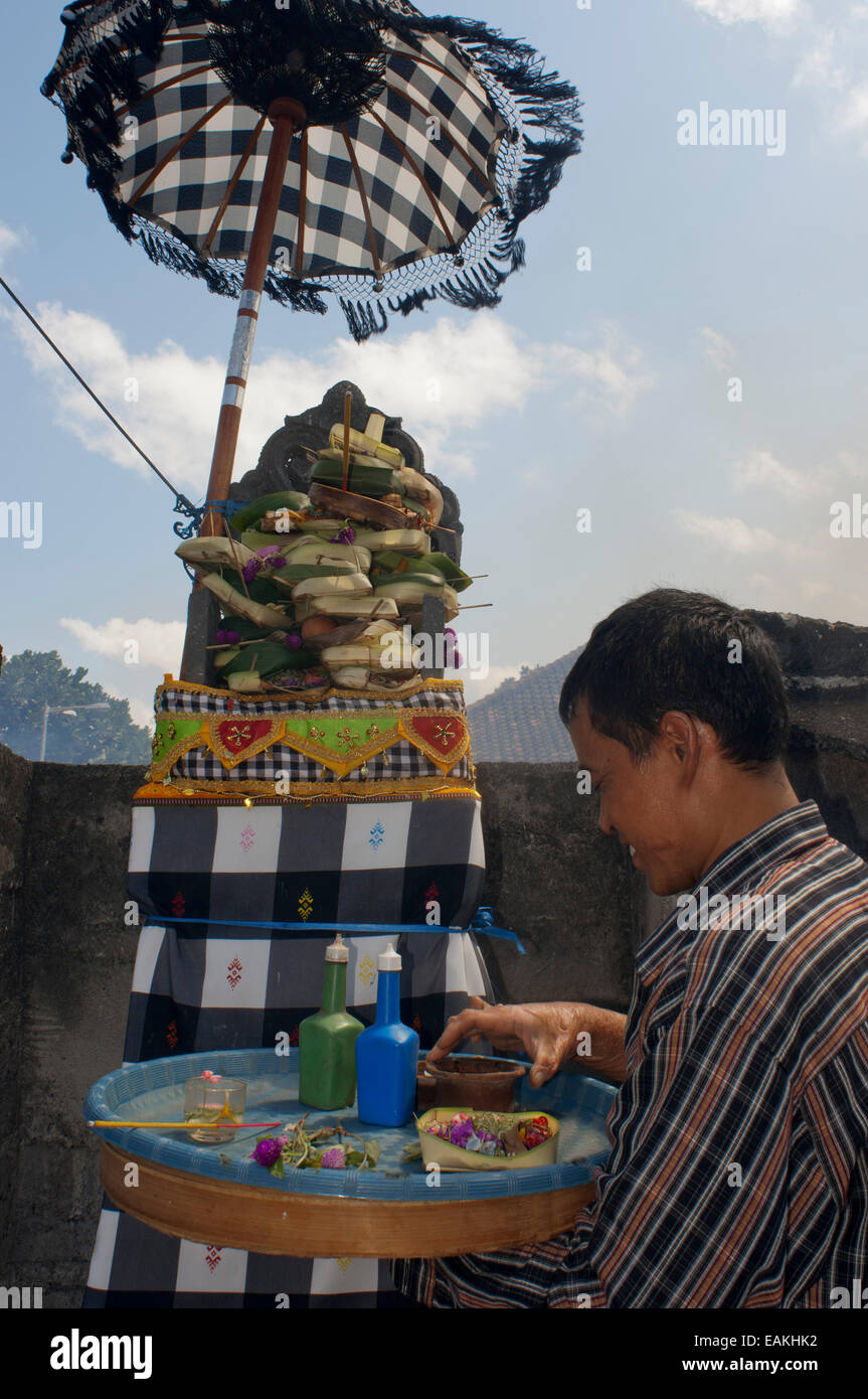 Homme balinais avec l'offre, dans un Kuta. Bali. L'Indonésie. Saraswati jour est une maison de style balinais traditionnel pour célébrer le jour où Banque D'Images