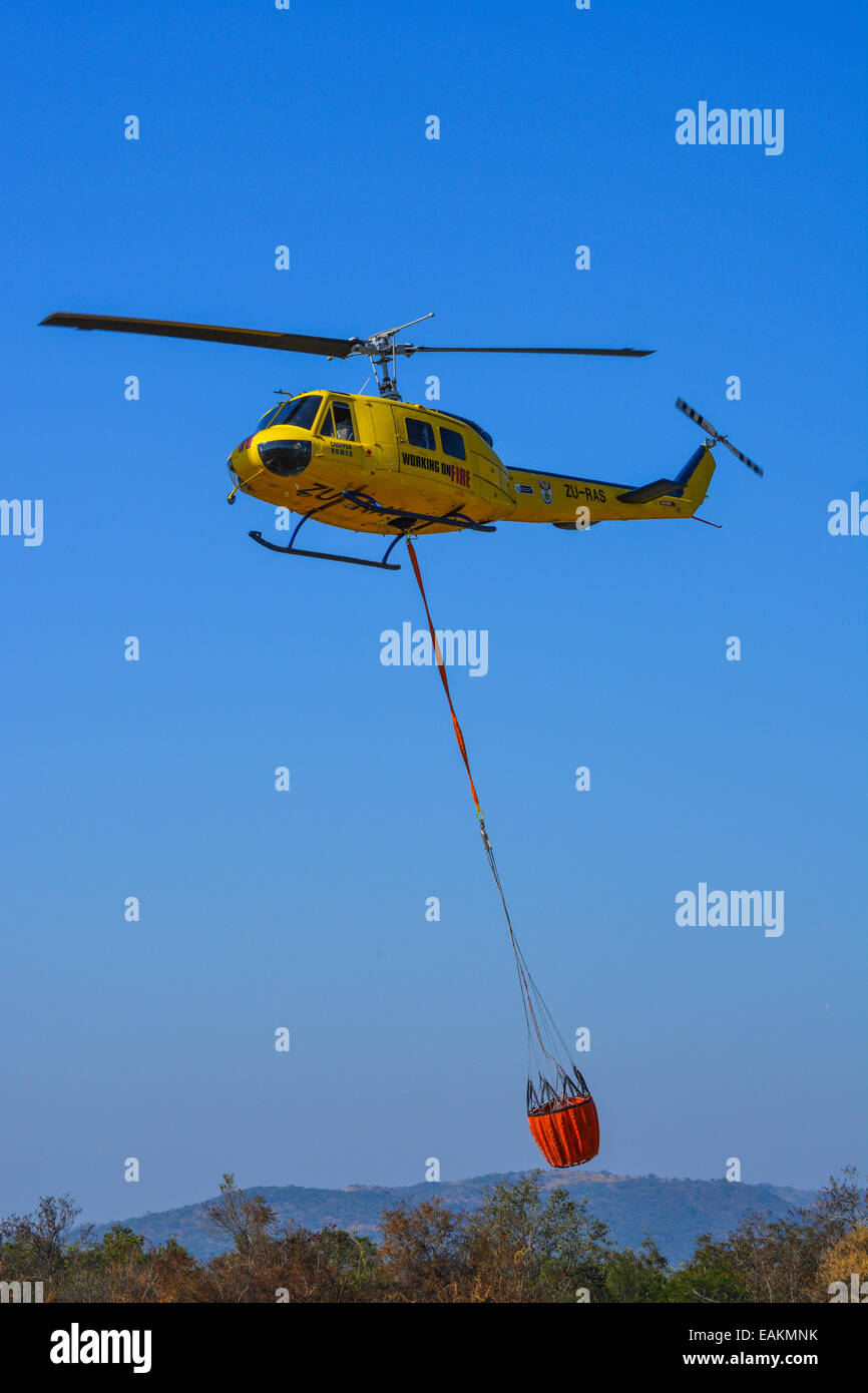 Hélicoptère de lutte contre l'incendie avec un seau plein d'eau Banque D'Images