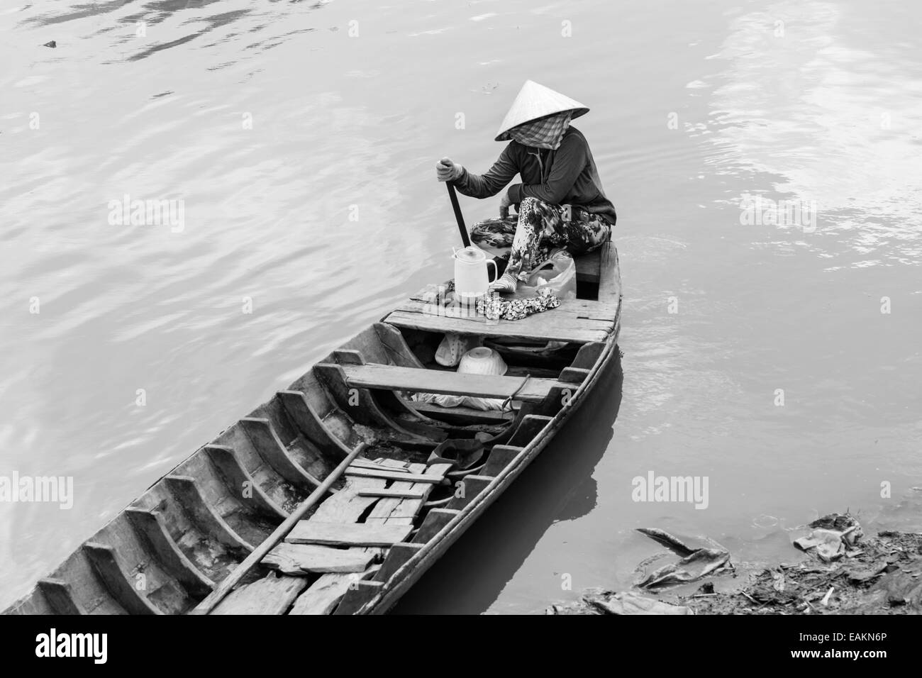 Femme assise dans un bateau sur la rivière à Tra Vinh, Vietnam, le delta du Mékong. Banque D'Images