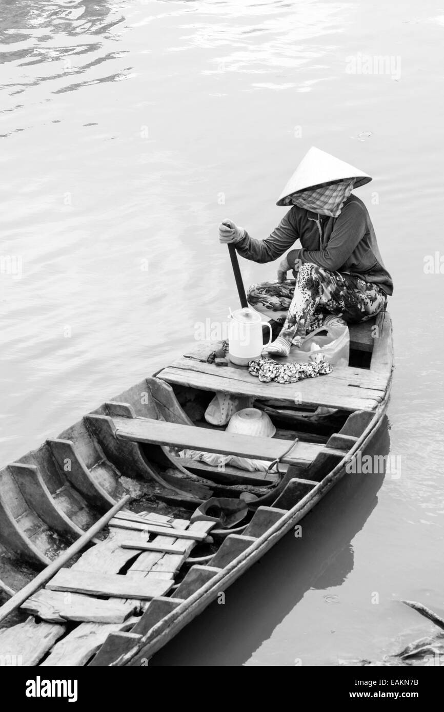 Femme assise dans un bateau sur la rivière à Tra Vinh, Vietnam, le delta du Mékong. Banque D'Images
