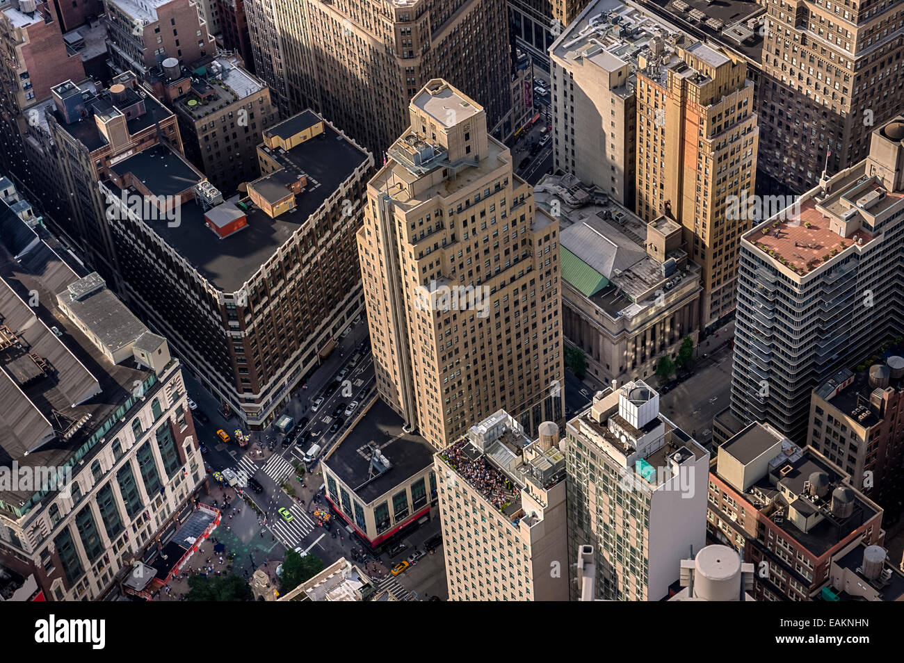 Les gens tournée des bars et restaurants comme la fin de l'après-midi soleil projette l'ombre parmi les hauts immeubles de Midtown Manhattan Banque D'Images