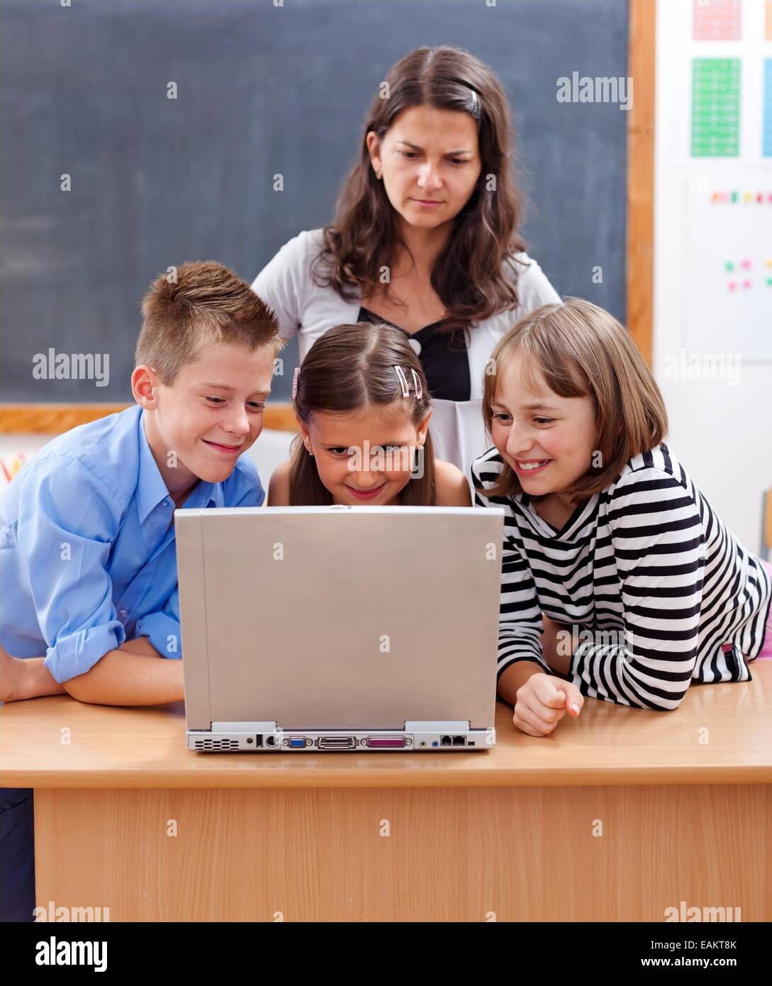 Les enfants de surfer sur internet, regarder le contenu dangereux. Professeur se tient derrière et les inquiétudes au sujet de Banque D'Images