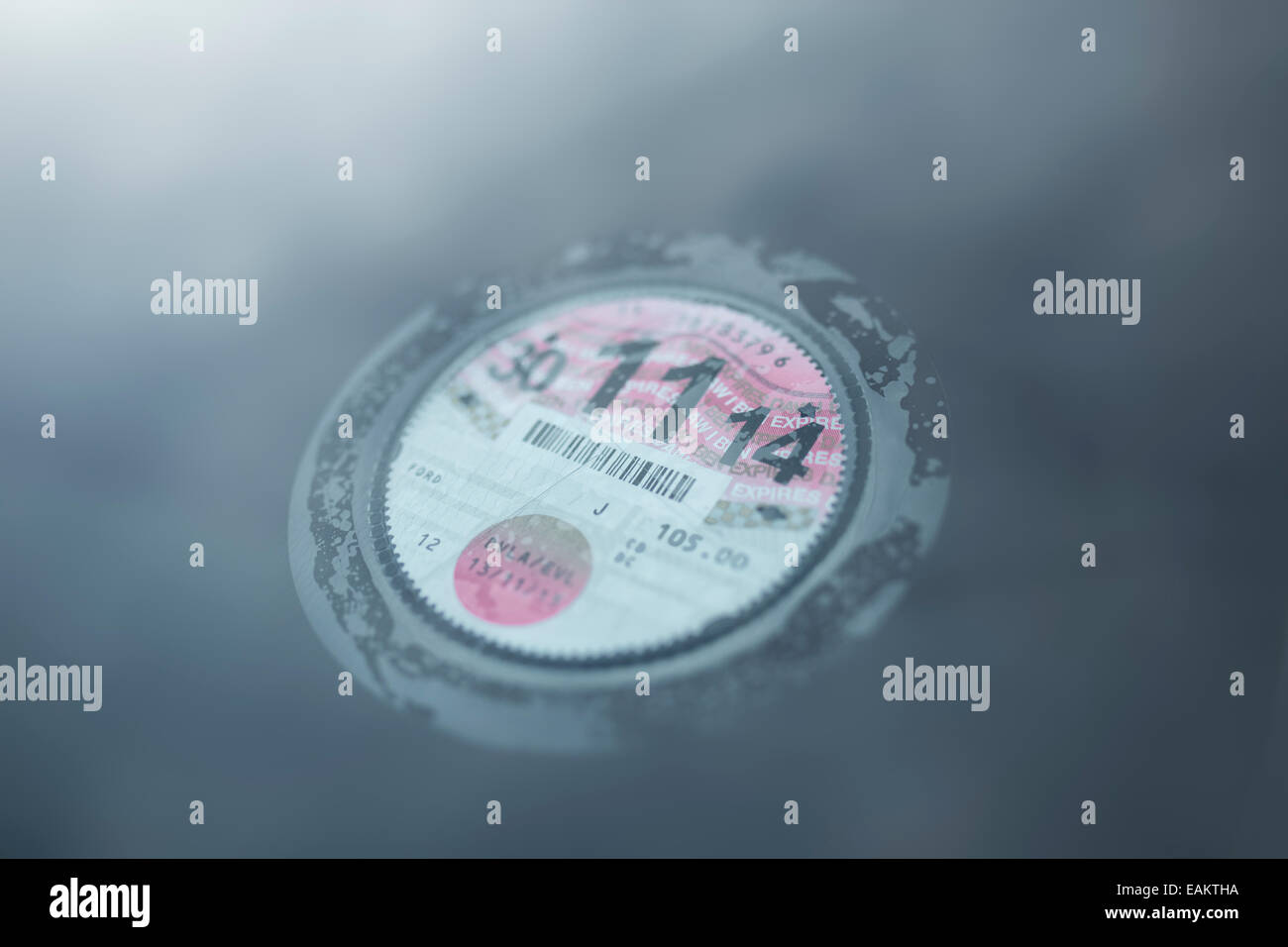 La taxe automobile britannique disc collée à l'intérieur d'un pare-brise du véhicule. Banque D'Images