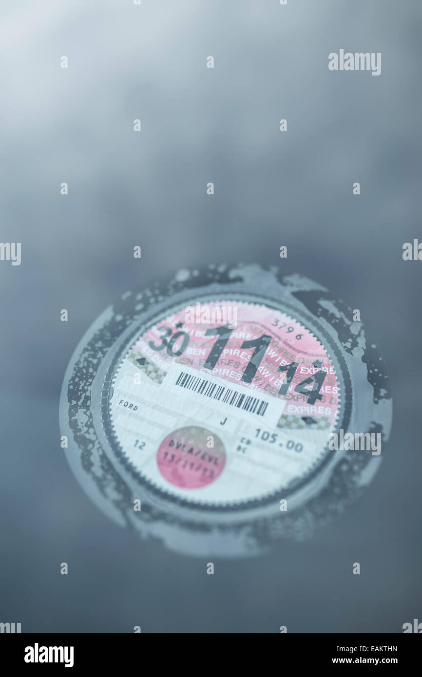 La taxe automobile britannique disc collée à l'intérieur d'un pare-brise du véhicule. Banque D'Images