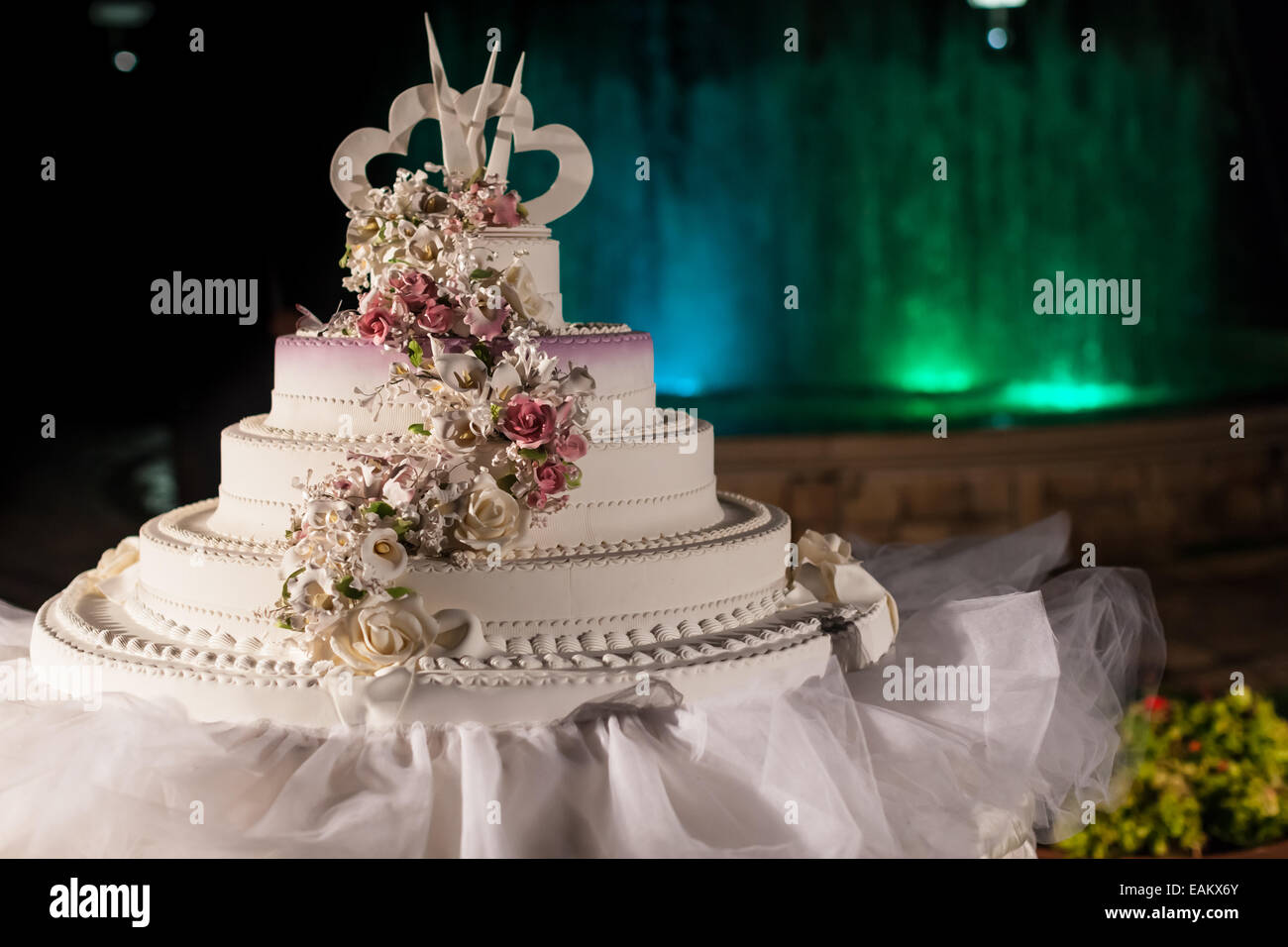 Un Gateau De Mariage Blanc Elegant Avec Une Fontaine Dans L Arriere Plan Photo Stock Alamy