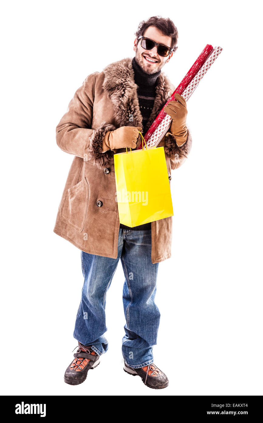 Un jeune homme portant un manteau en peau de mouton et la tenue du papier d'emballage pour les cadeaux de Noël. Isolated over white Banque D'Images