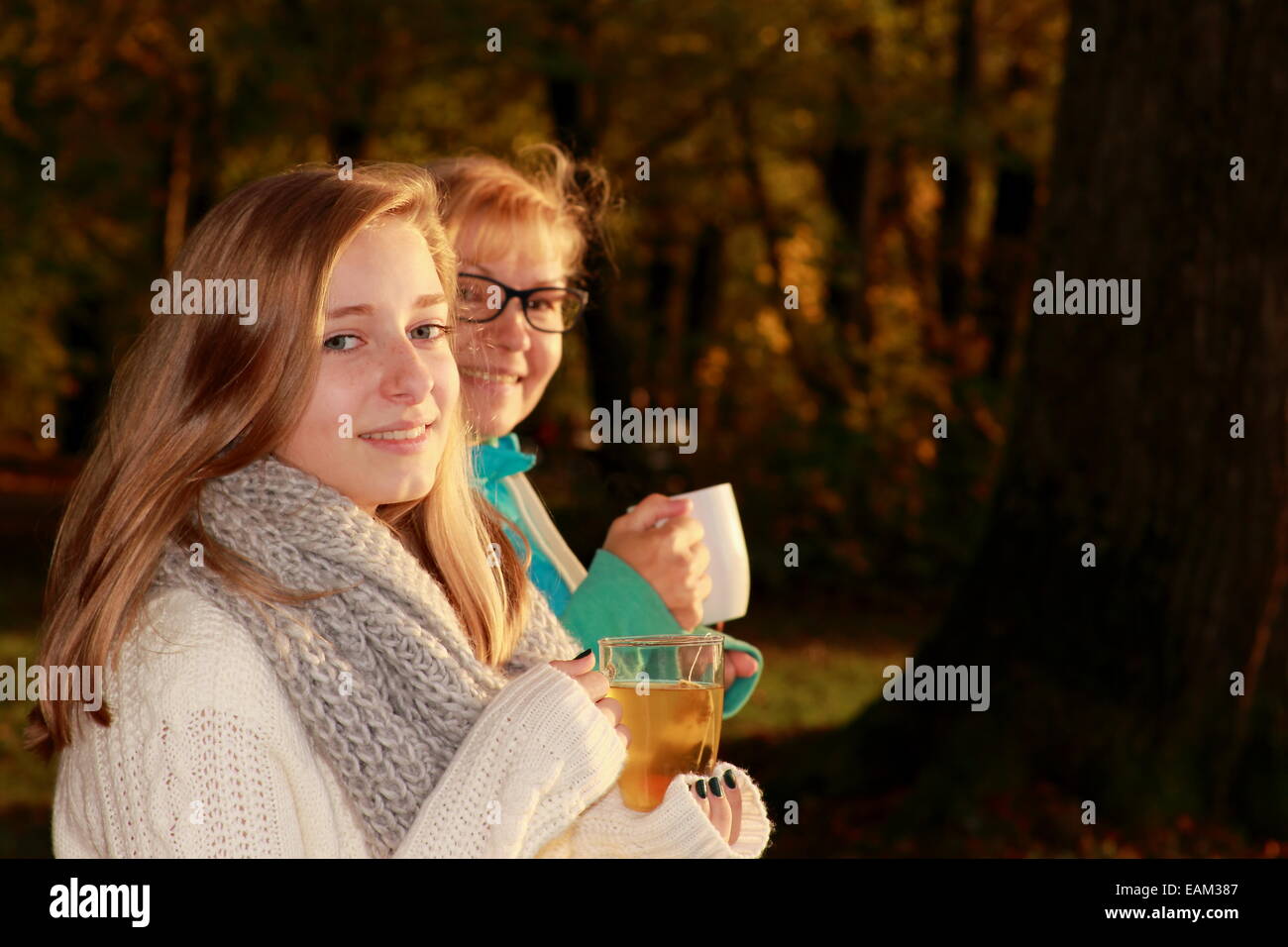 Mère et fille boire du thé en automne park, horizontal Banque D'Images