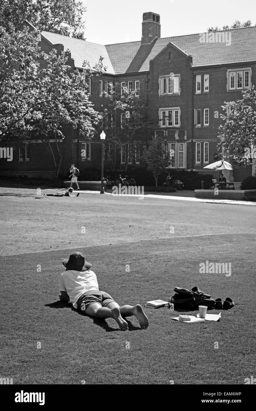 Étudiant couché sur l'herbe en face de Tolman Hall se détend sur le campus de l'Université Vanderbilt, Nashville, TN, en noir et blanc Banque D'Images