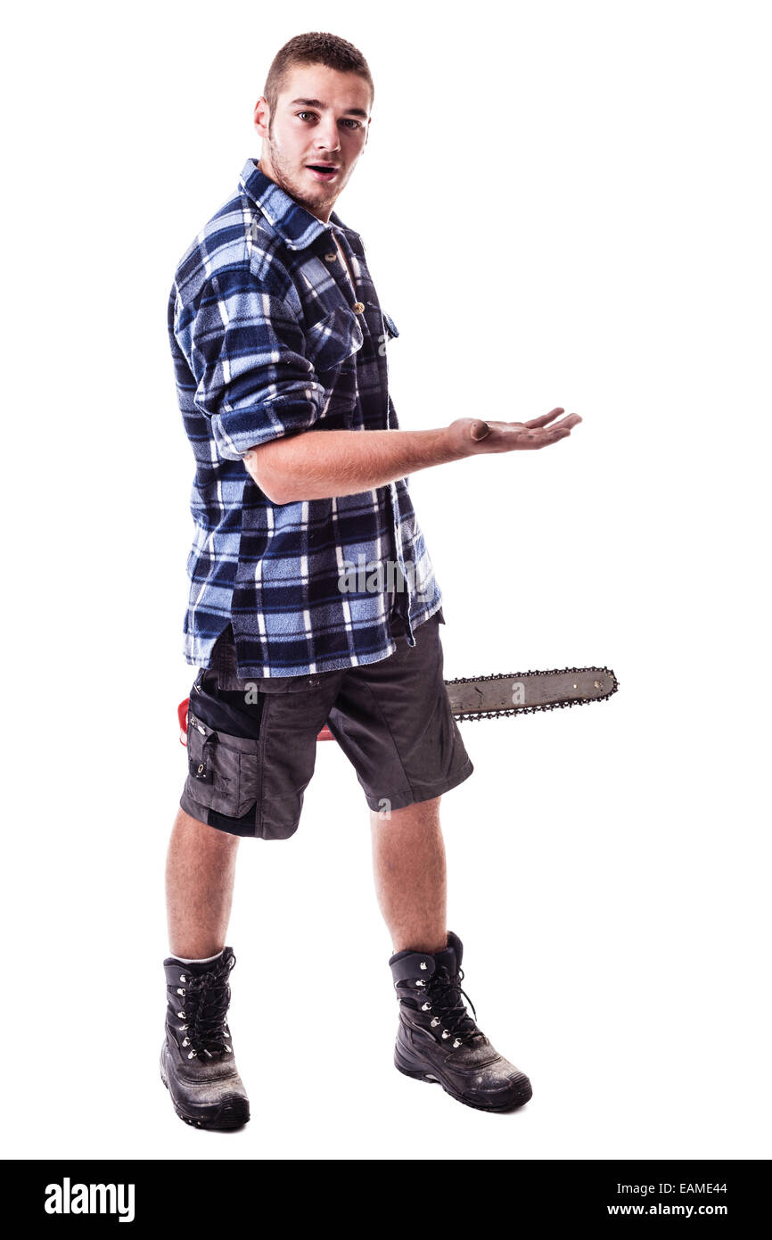 Un jeune bûcheron portant une chemise à carreaux à la main une scie à chaîne et montrant quelque chose d'isolé sur fond blanc Banque D'Images