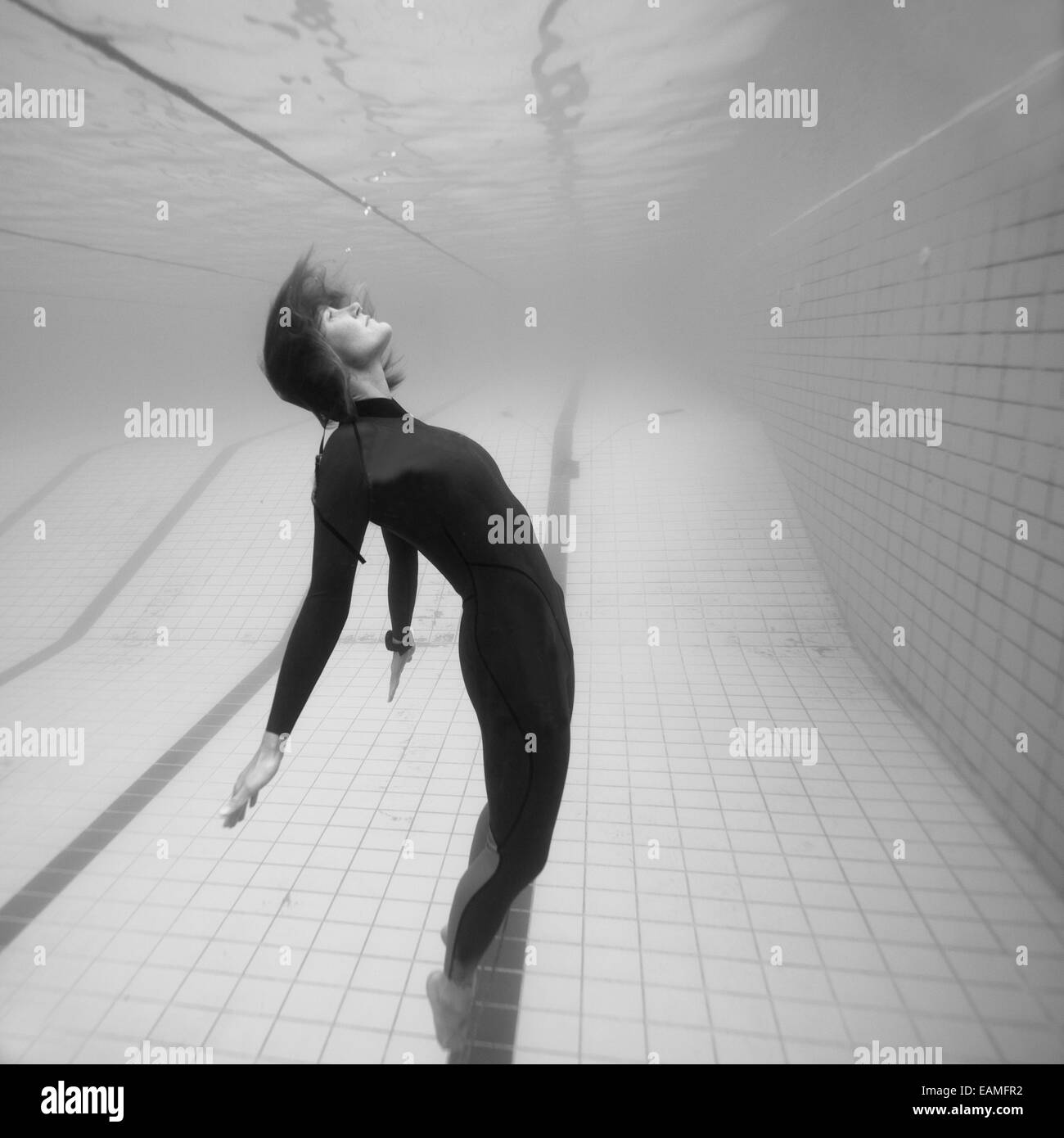 Image en noir et blanc de plongeur femelle qui semble être en suspension dans l'espace, tandis que sous l'eau dans siwmming extérieure Banque D'Images
