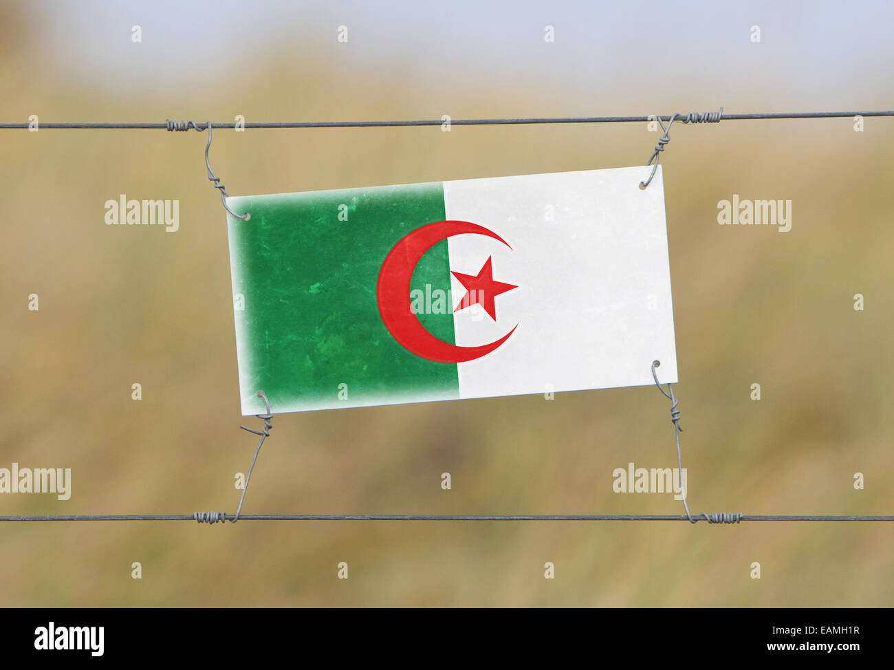 Frontière - vieux signe plastique avec un drapeau - Algérie Banque D'Images