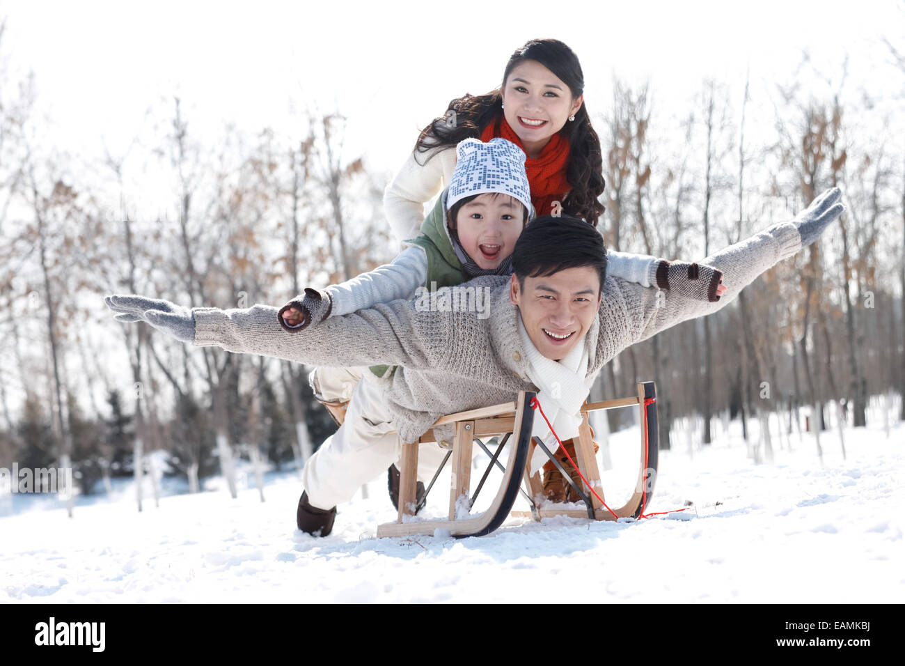 Seul enfant le ski en famille sur le traîneau Banque D'Images