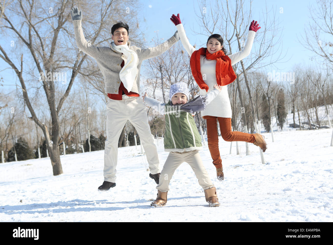 Les familles comptant un enfant jouer dans la neige Banque D'Images