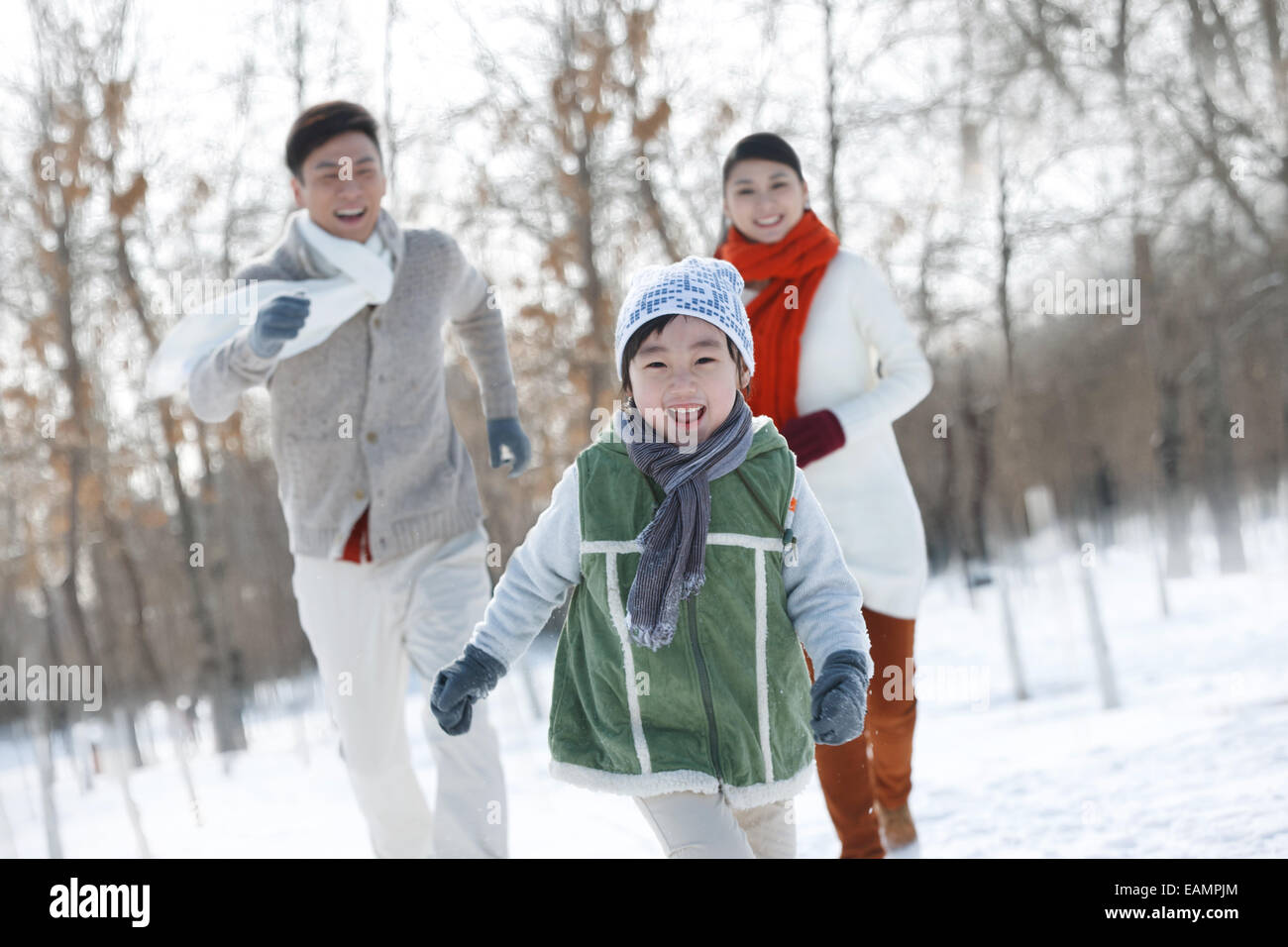La famille de l'enfant uniquement en marche dans la neige Banque D'Images