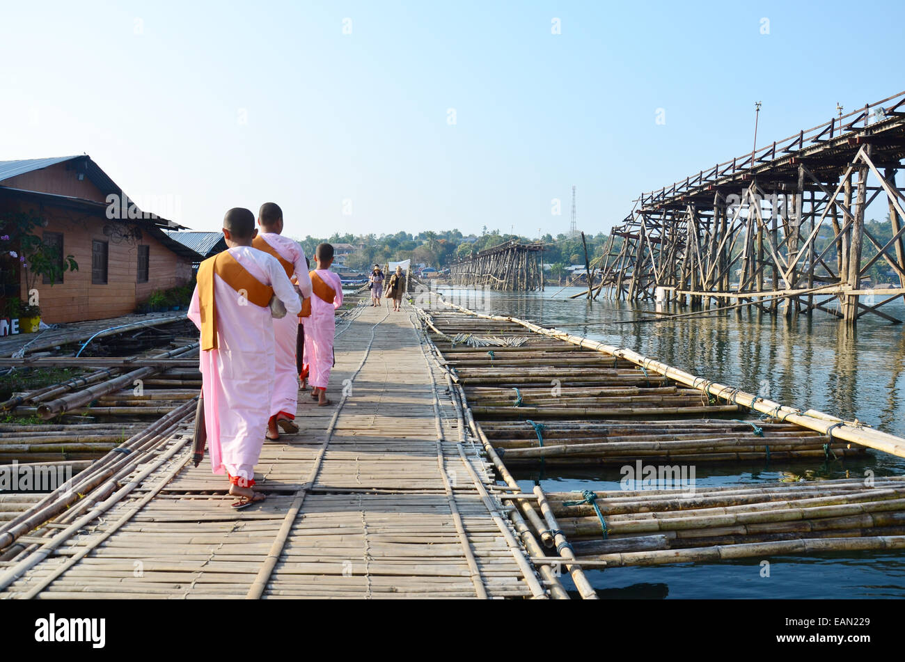 Nun ou femmes ascétique marche sur un pont de bambou au lieu d'utilisation Saphan Mon pont en bois à Sangkhlaburi à Kanchanaburi. Banque D'Images