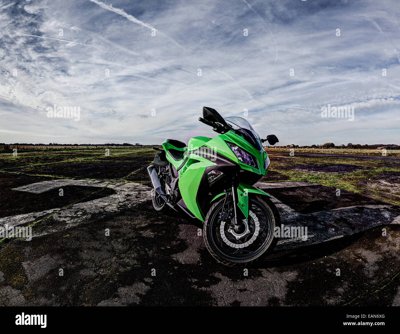 Moto sport verte placée sur une piste de l'aérodrome désaffecté Banque D'Images